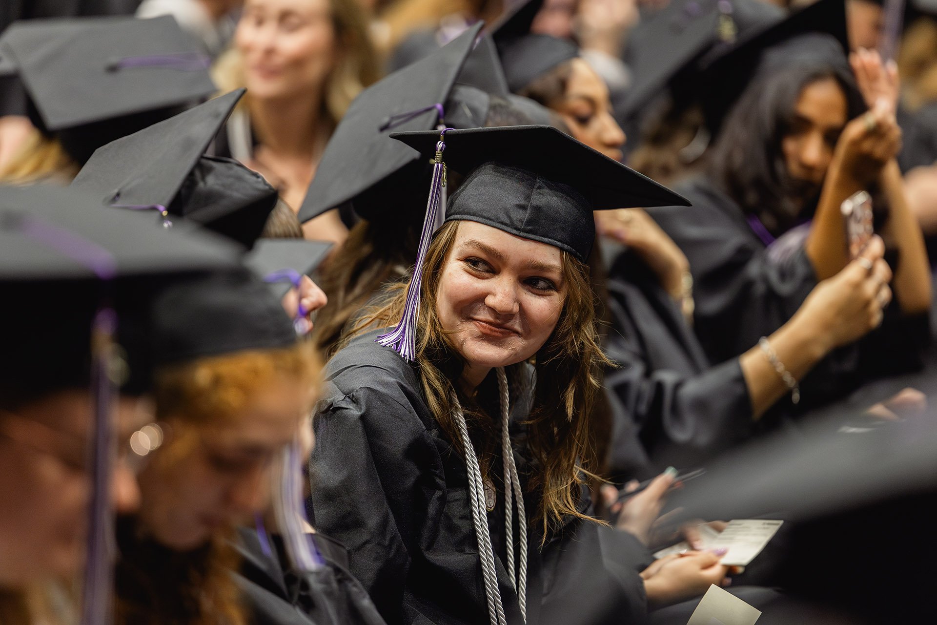 2025-Commencement-Grad-Looking-Over-Shoulder