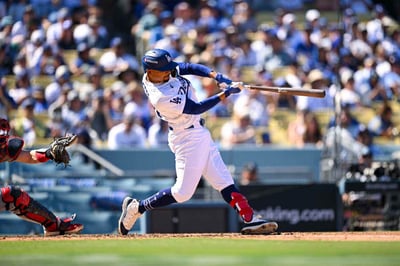 Mookie Betts swinging the bat at a baseball game.