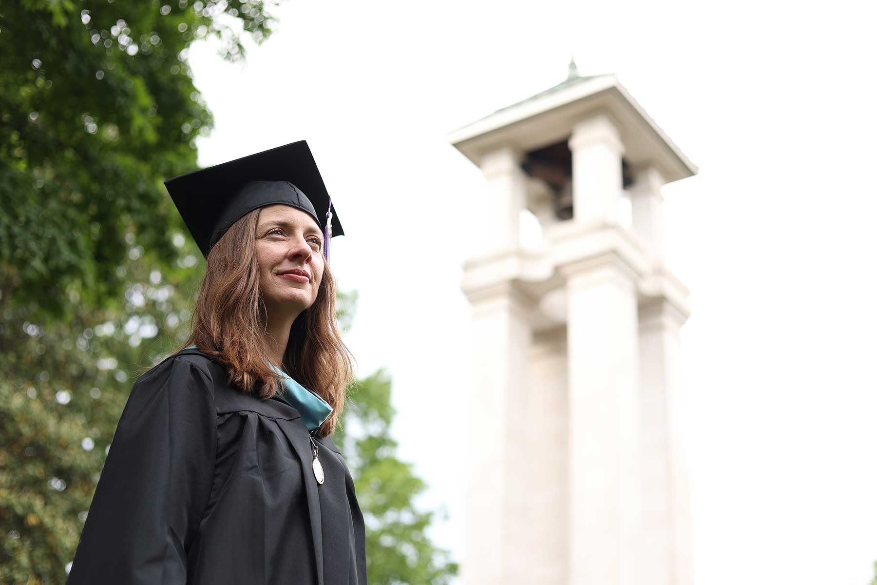 Cynthia Head poses for a photo at Trevecca's iconic bell tower on graduation.