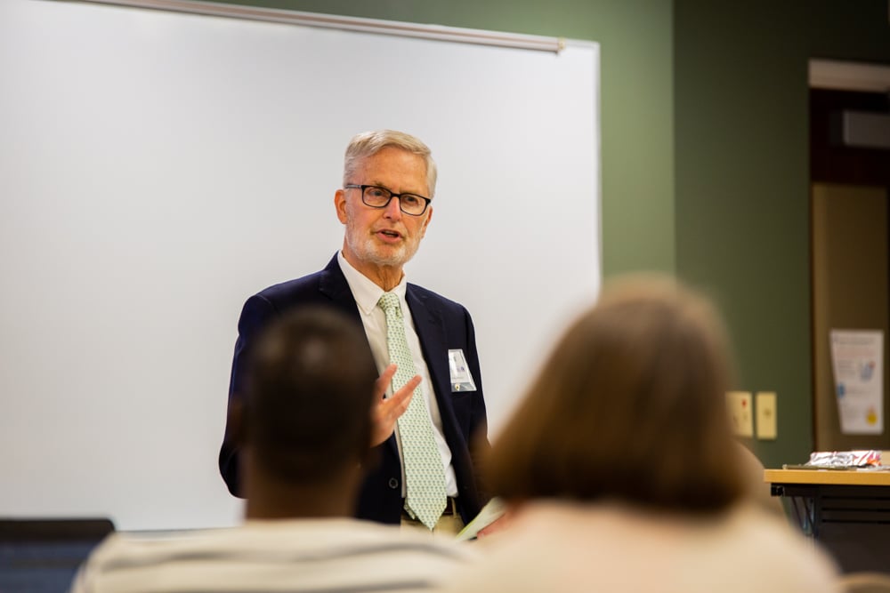 A professor lectures students in a classroom.