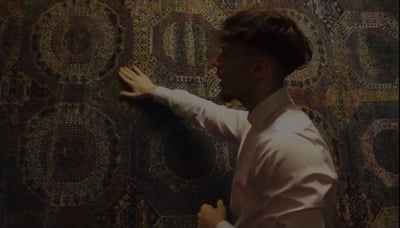 Potka looks over one of his rugs.