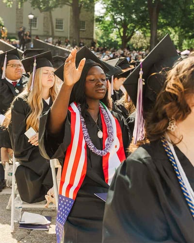 Salama Edita prays at Commencement.